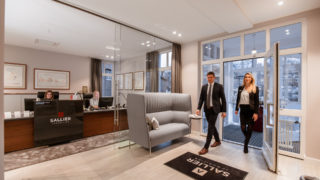 Eingang Immobilienbüro Sallier Immobilien zwei Menschen betreten den Empfangsbereich